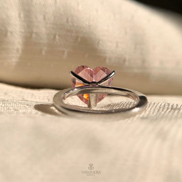 Elegant heart shaped solitaire pink diamond engagement ring with pave set band