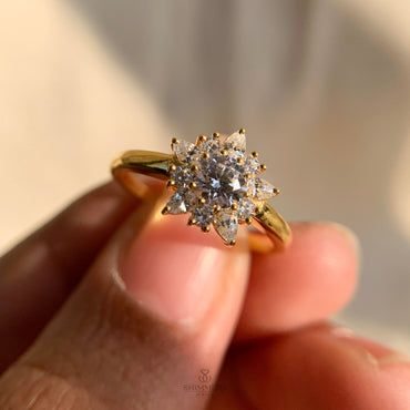 Elegant engagement ring with round and pear shaped diamond cluster