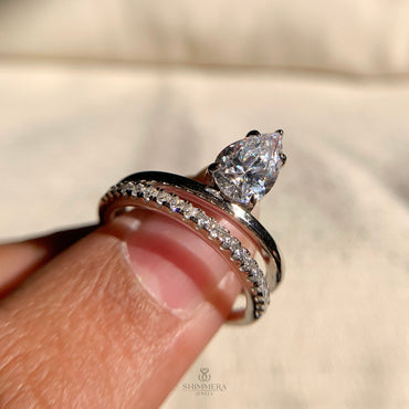 "Elegant pear-shaped solitaire ring with double band design"