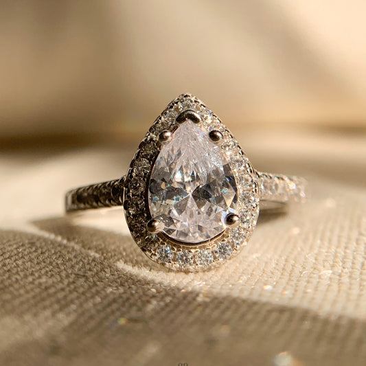 “Pear cut halo engagement ring in 14k white gold with sparkling accent diamonds”