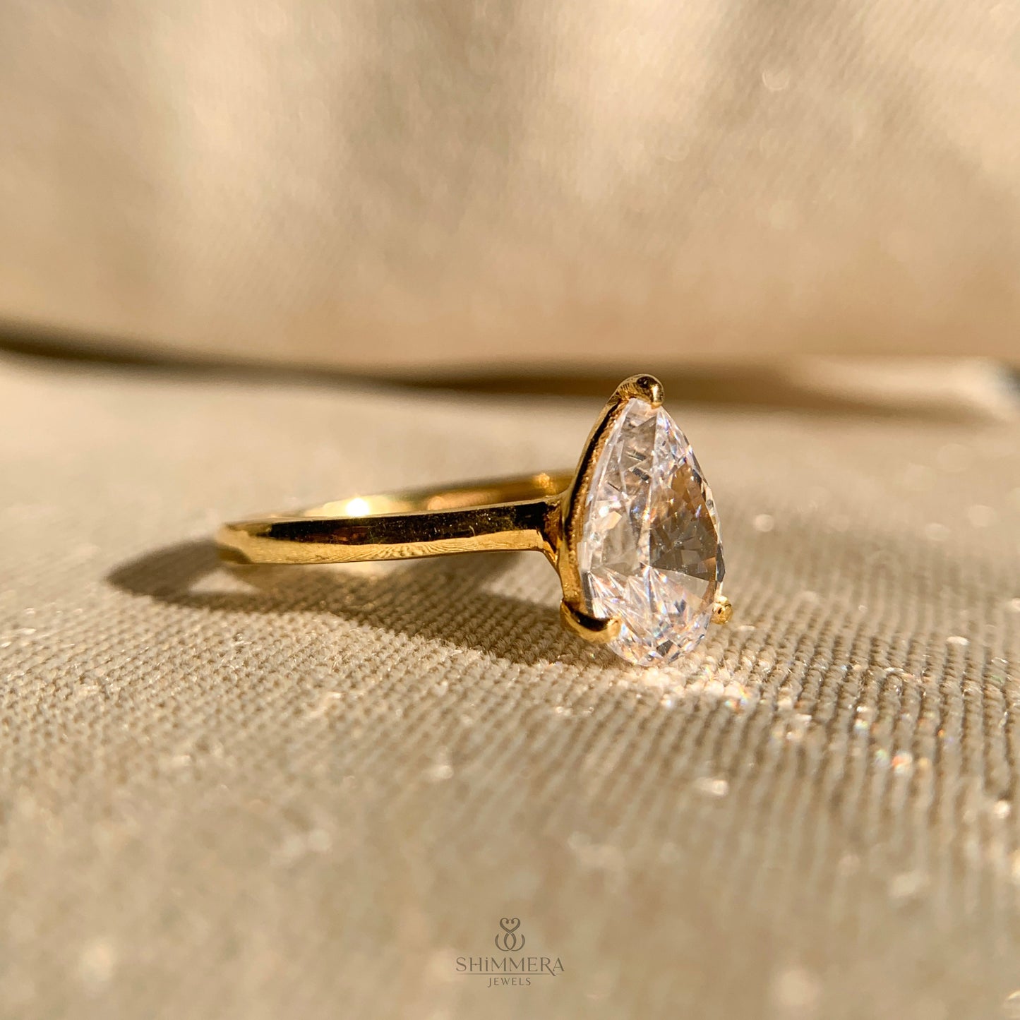 Delicate pear shape moissanite engagement ring with sleek band