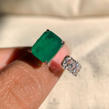 “Unique open band wedding ring with emerald gemstone and oval cut diamond”