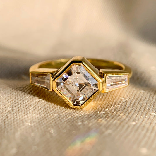 Elegant Asscher and baguette bezel set three stone engagement ring in white gold