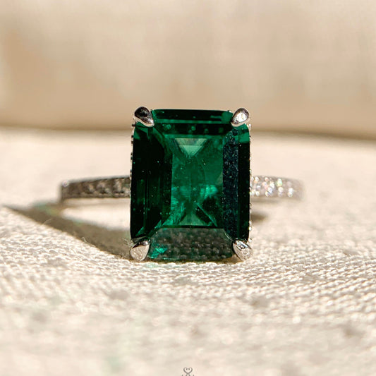 Radiant cut emerald gemstone solitaire engagement ring in sleek gold setting – shop online