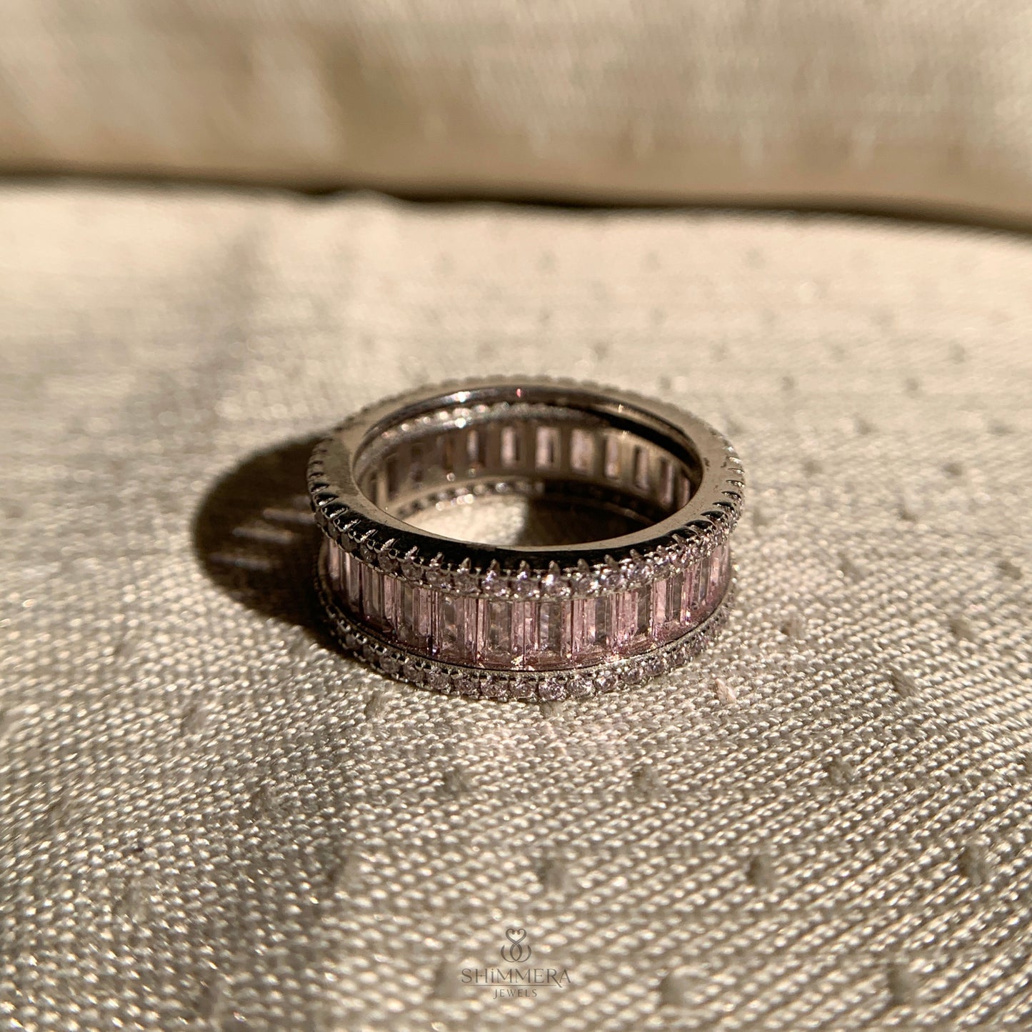 Dainty pink baguette eternity band in polished white gold finish