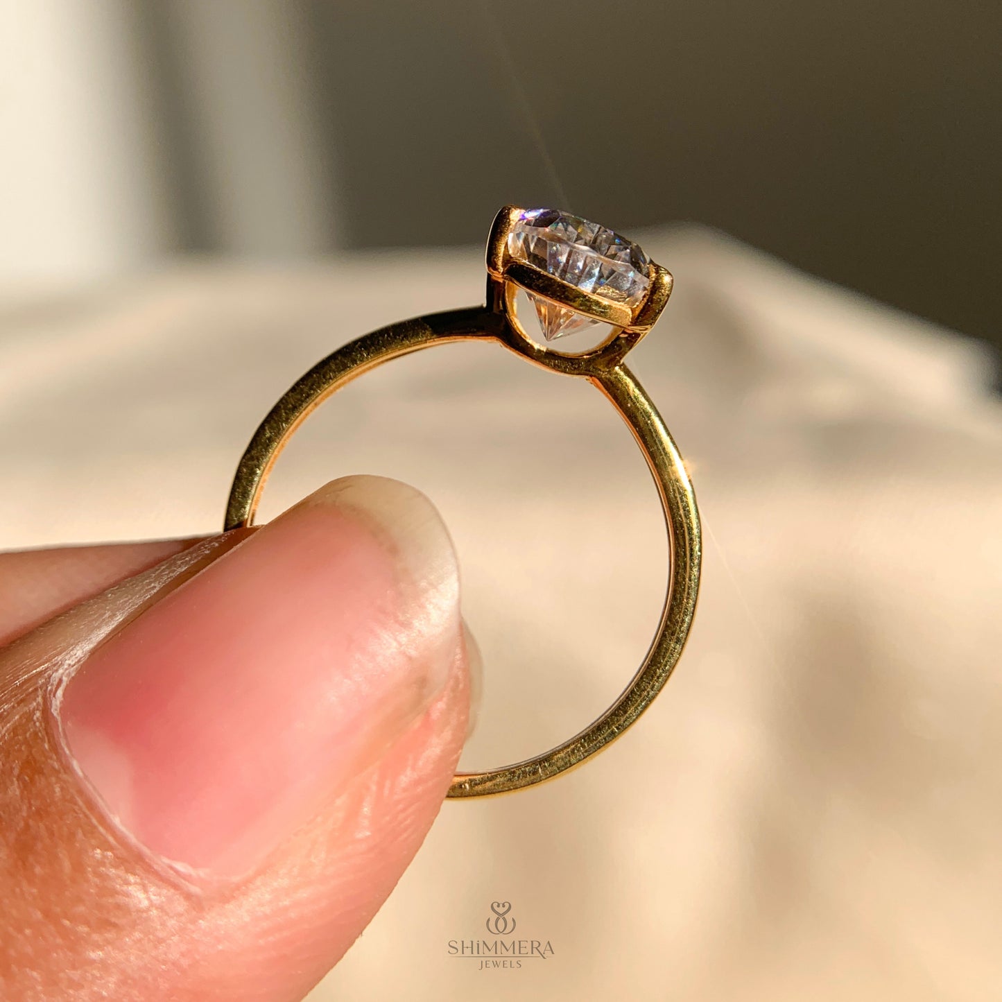 Modern solitaire engagement ring featuring pear cut moissanite stone