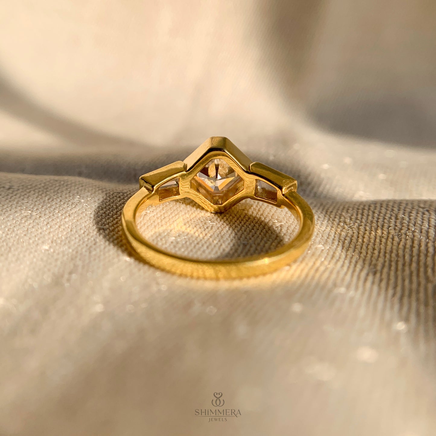 Three stone Asscher and baguette diamond engagement ring in sleek bezel setting