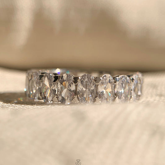 Half oval cut half emerald cut moissanite eternity band in sleek white gold