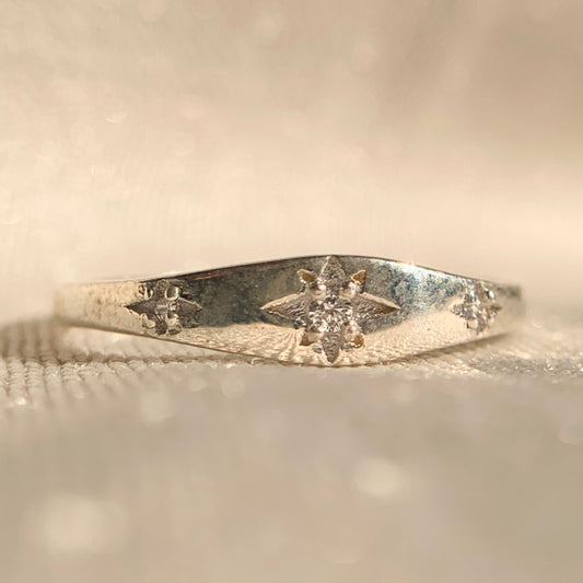 14k white gold star burst ring with sparkling diamond center