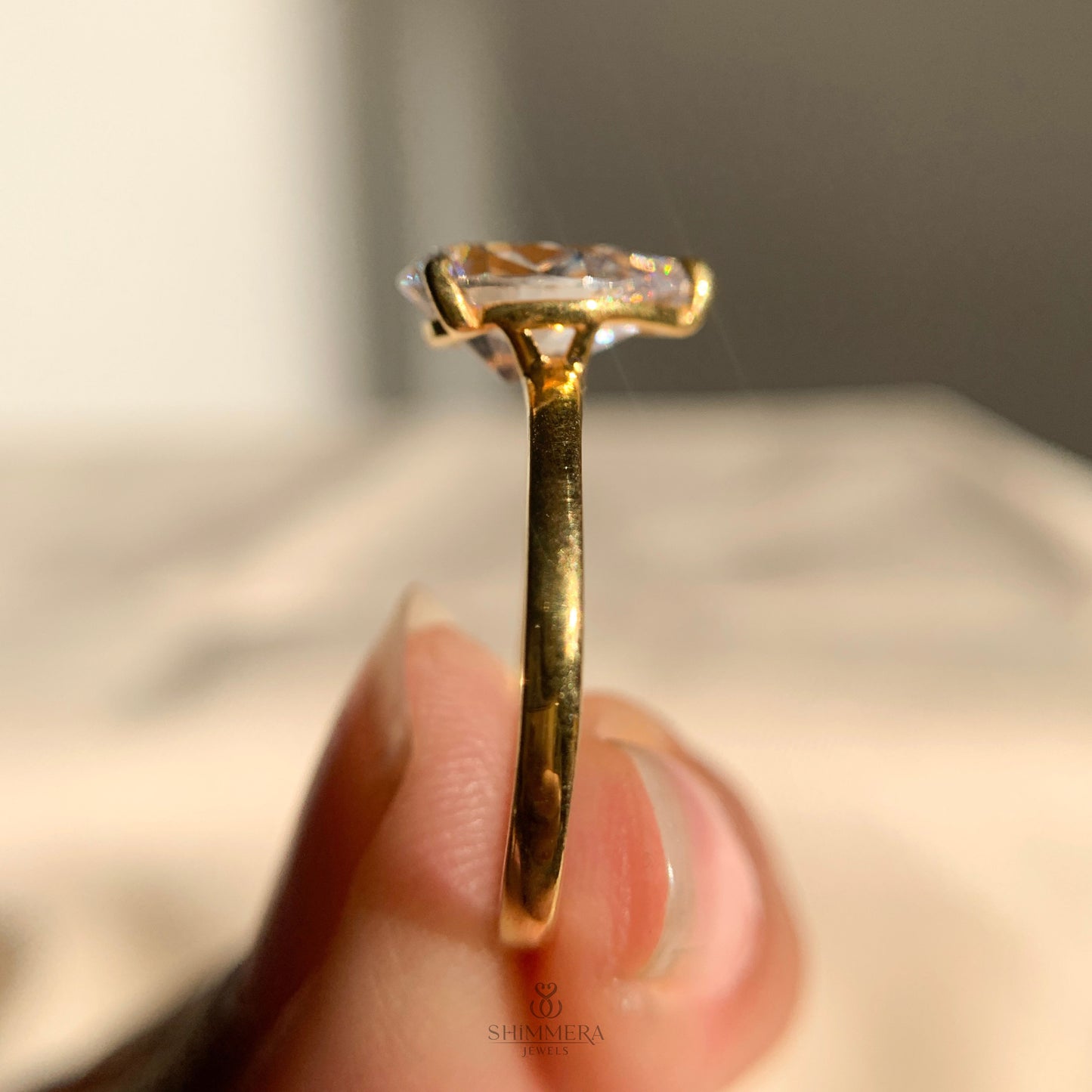 Minimalist pear shaped moissanite ring set in polished gold