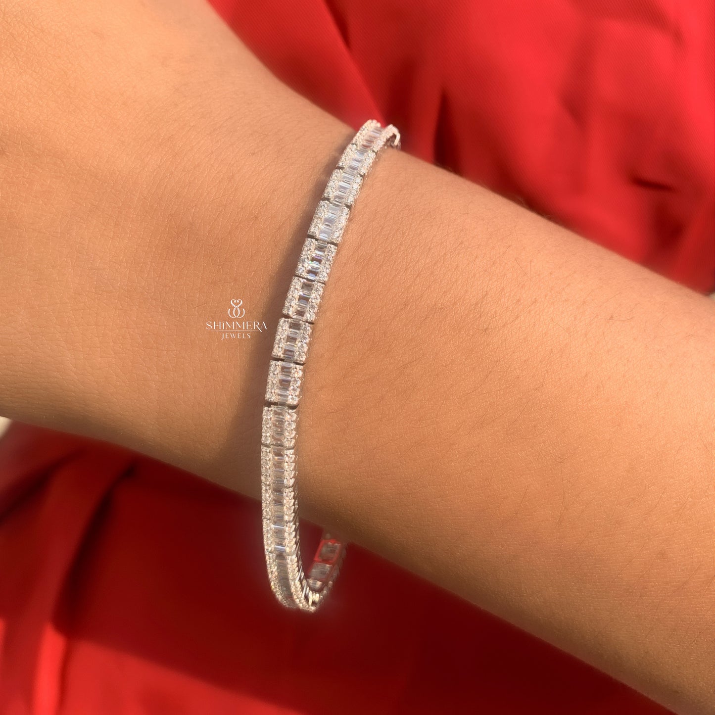 Silver bracelet with diamonds on a wrist against a red background, featuring Shri Kiran Jewels logo.