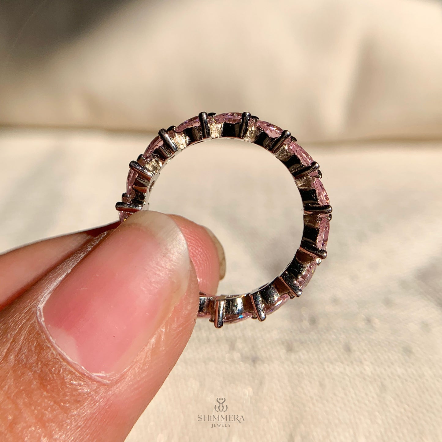 Delicate pink diamond eternity band featuring continuous heart-shaped stones