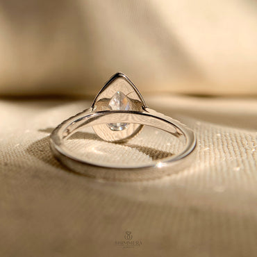 “Elegant pear shaped diamond halo ring set in polished white gold”