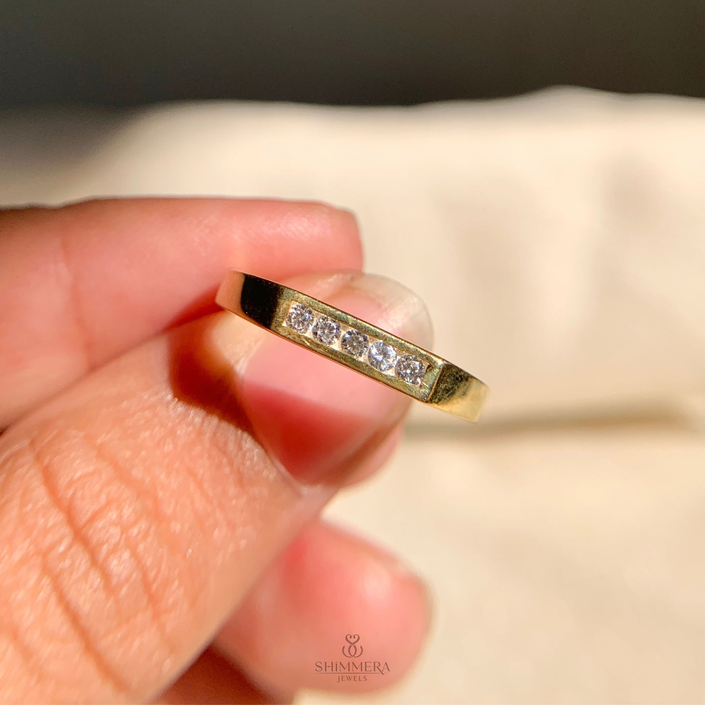 Delicate yellow gold ring featuring five tiny diamonds