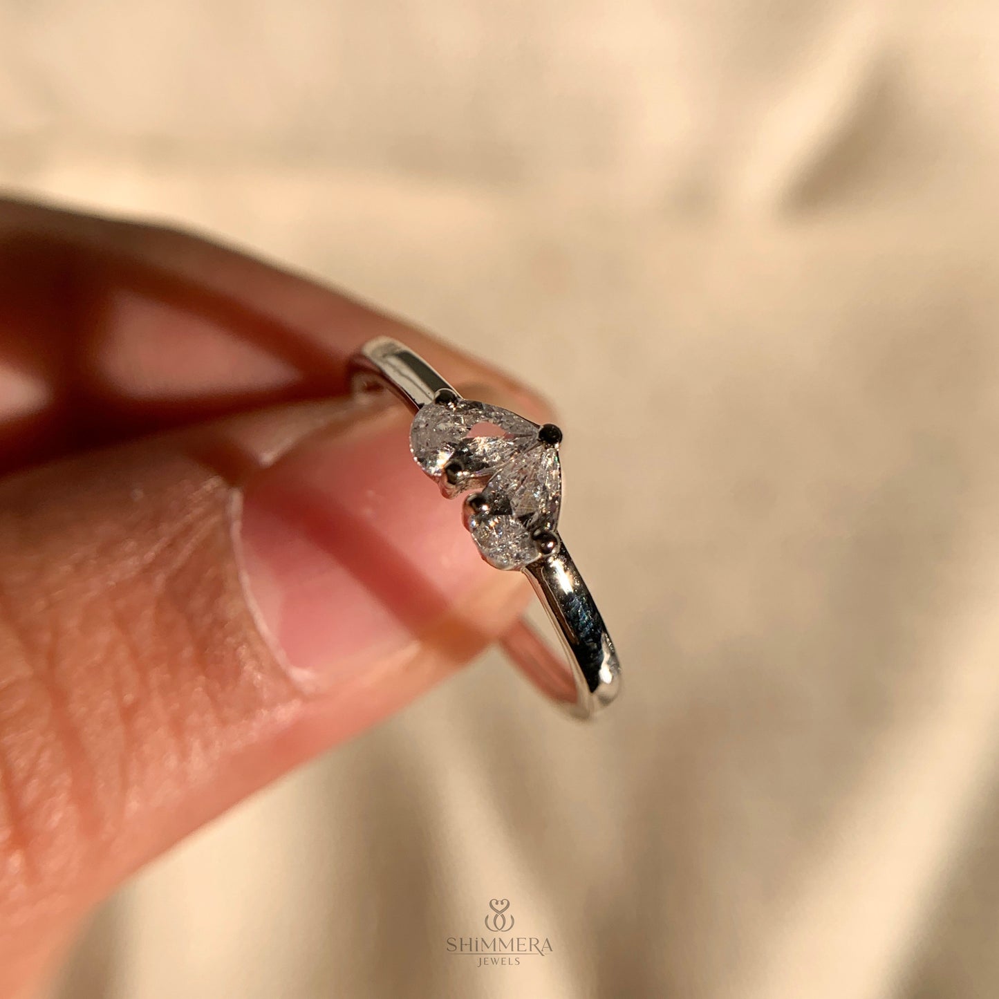 "Pear-shaped diamond Toi et Moi ring with intricate band detailing"