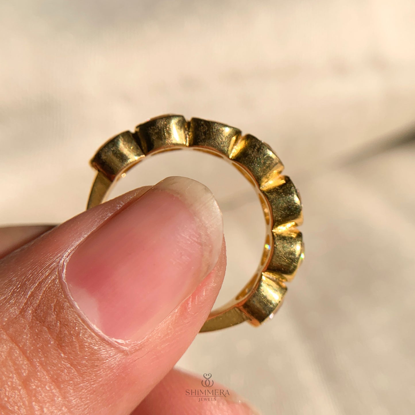 “Delicate bezel set diamond band featuring round cut stones”