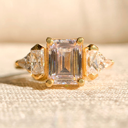 Emerald cut moissanite three stone engagement ring in white gold