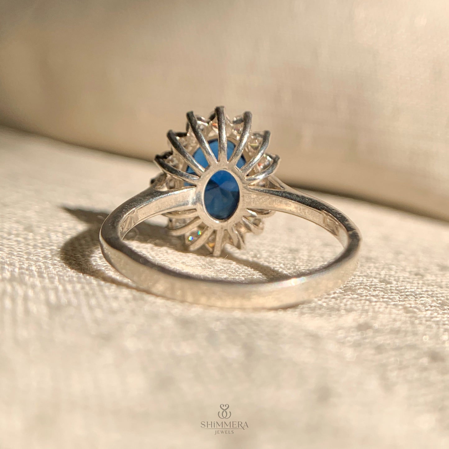 14k gold engagement ring featuring oval blue sapphire and diamond halo