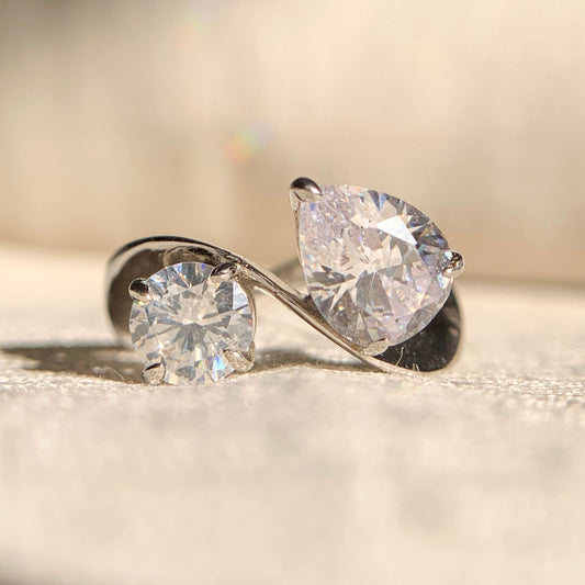 Toi et Moi engagement ring with round and pear diamonds in a luxurious setting