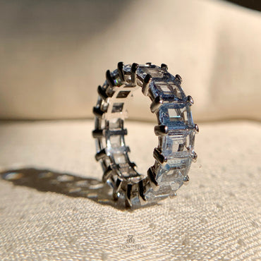 Dainty aquamarine eternity ring in warm rose gold setting