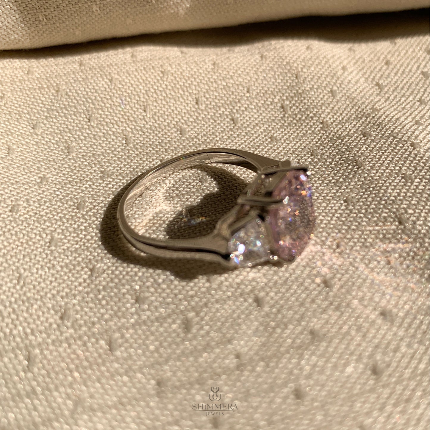 "Classic three stone engagement ring with emerald and Cadillac design"