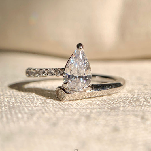 “Elegant pear shaped diamond solitaire engagement ring in polished gold band”