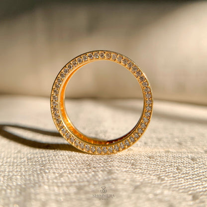 Gold ring with diamond accents on a textured surface