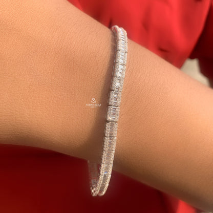 Silver bracelet on a wrist with a red background