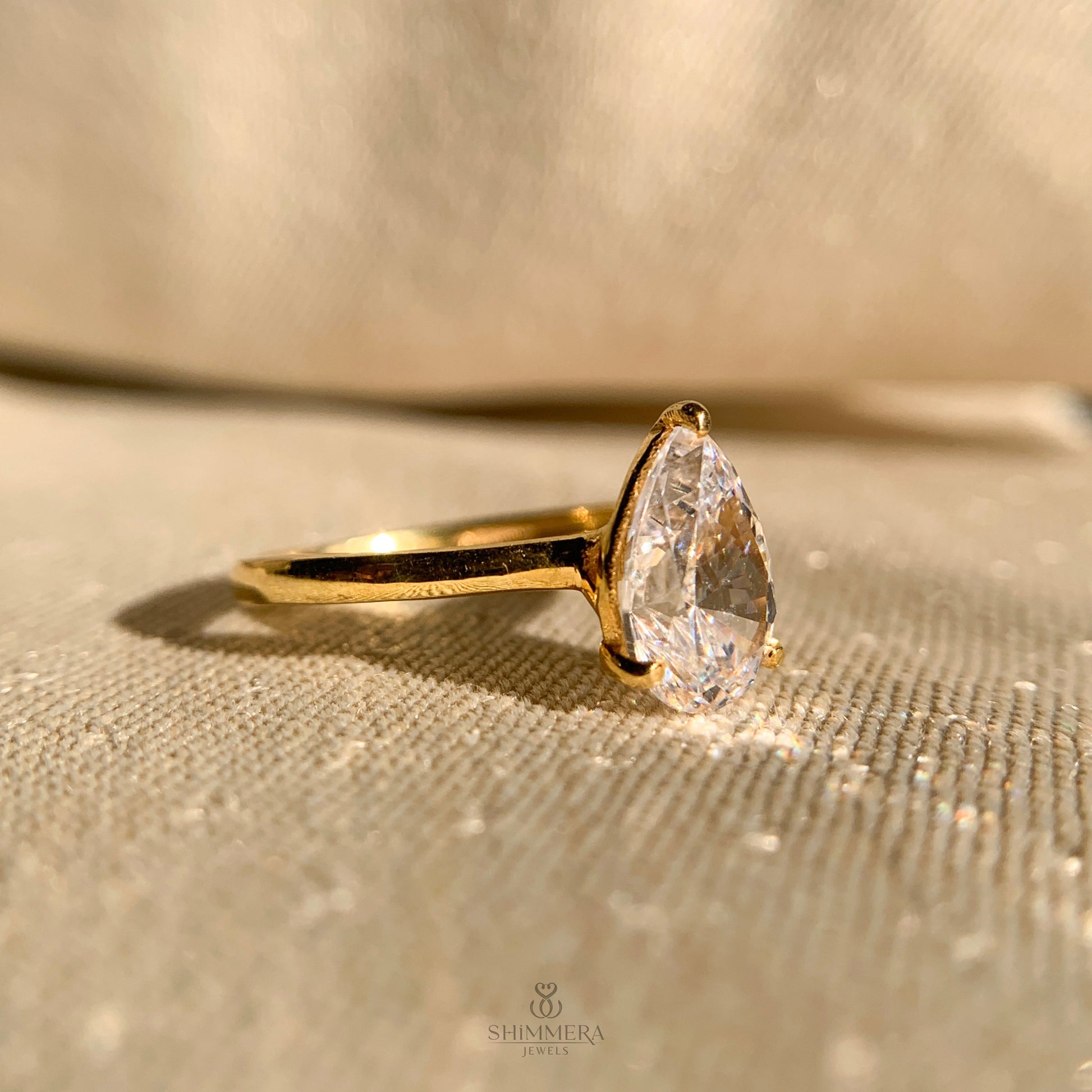 Delicate pear shape moissanite engagement ring with sleek band