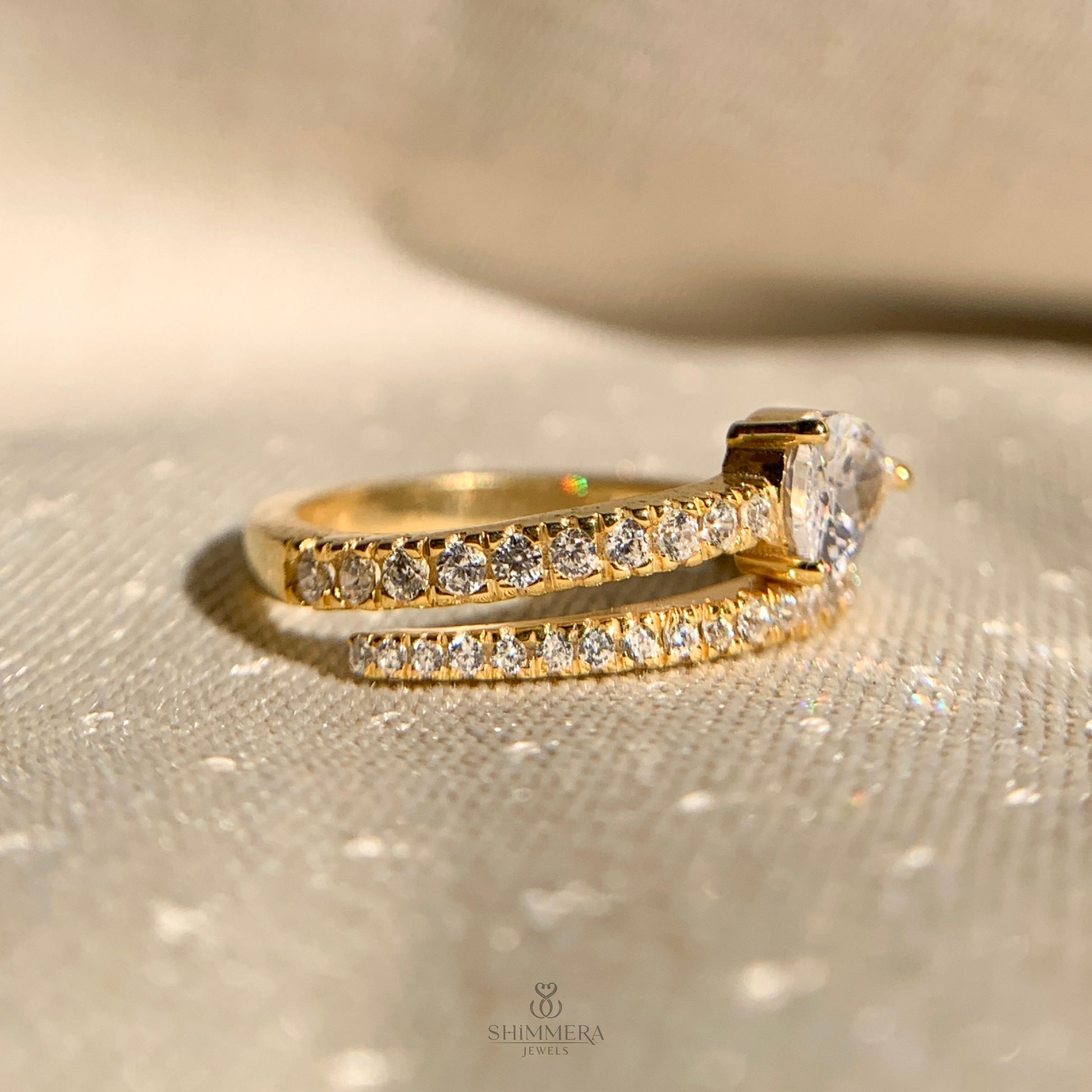 Contemporary bypass engagement ring featuring pear shaped diamond set sideways