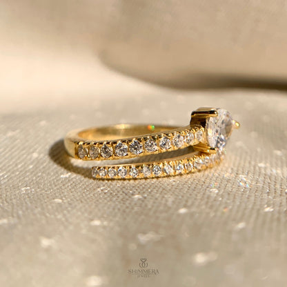 Contemporary bypass engagement ring featuring pear shaped diamond set sideways