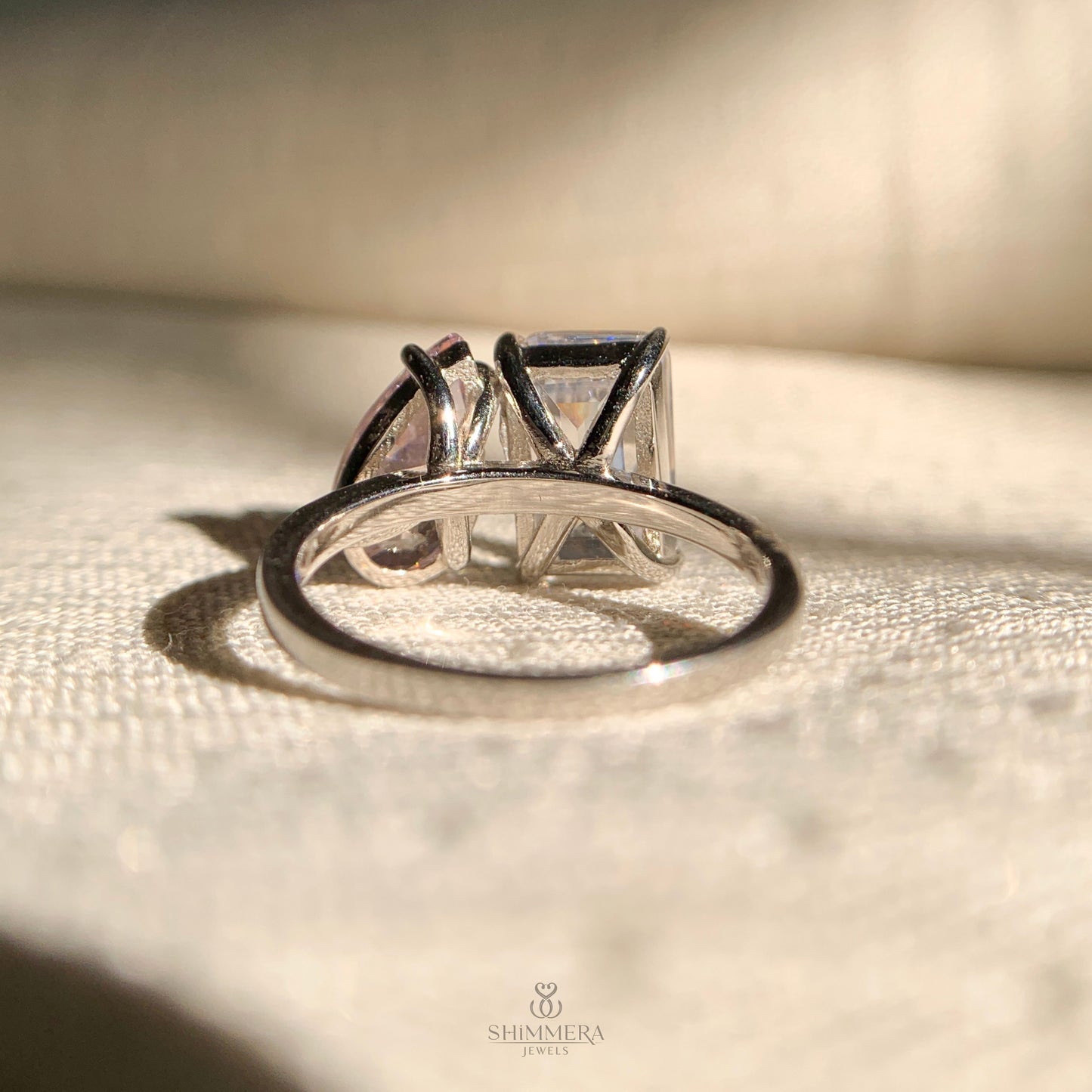 Luxury two stone diamond ring with emerald and pear shaped diamonds