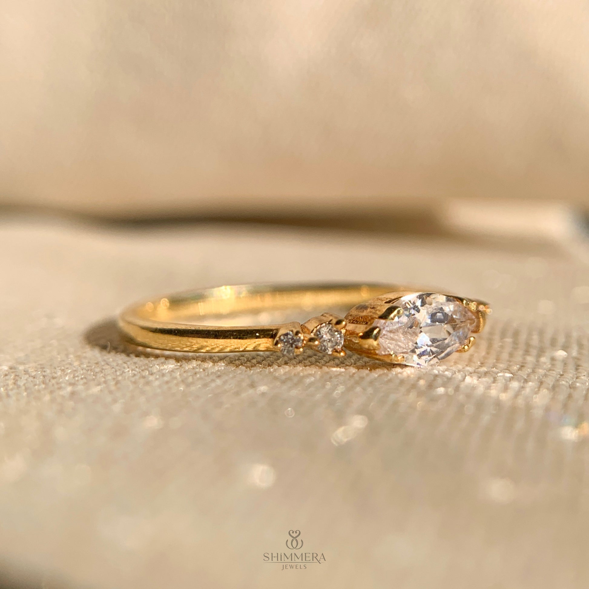 Dainty gold band featuring an east-west set marquise diamond