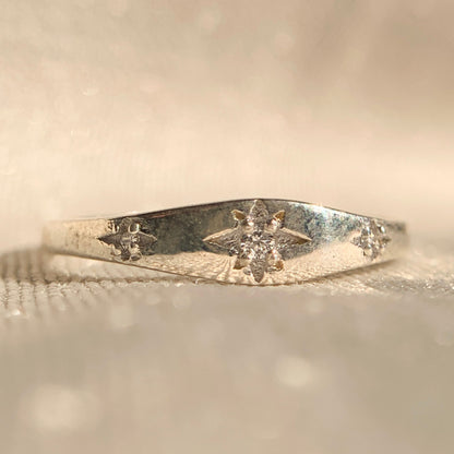 14k white gold star burst ring with sparkling diamond center