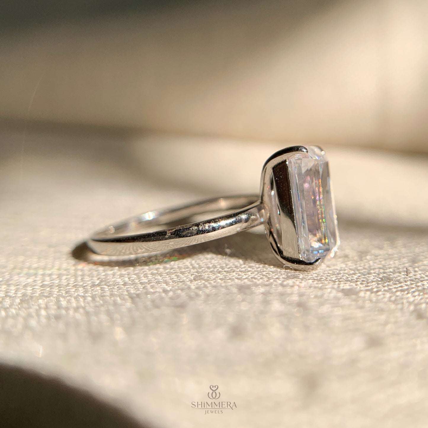 Unique emerald and pear cut double diamond ring in platinum finish
