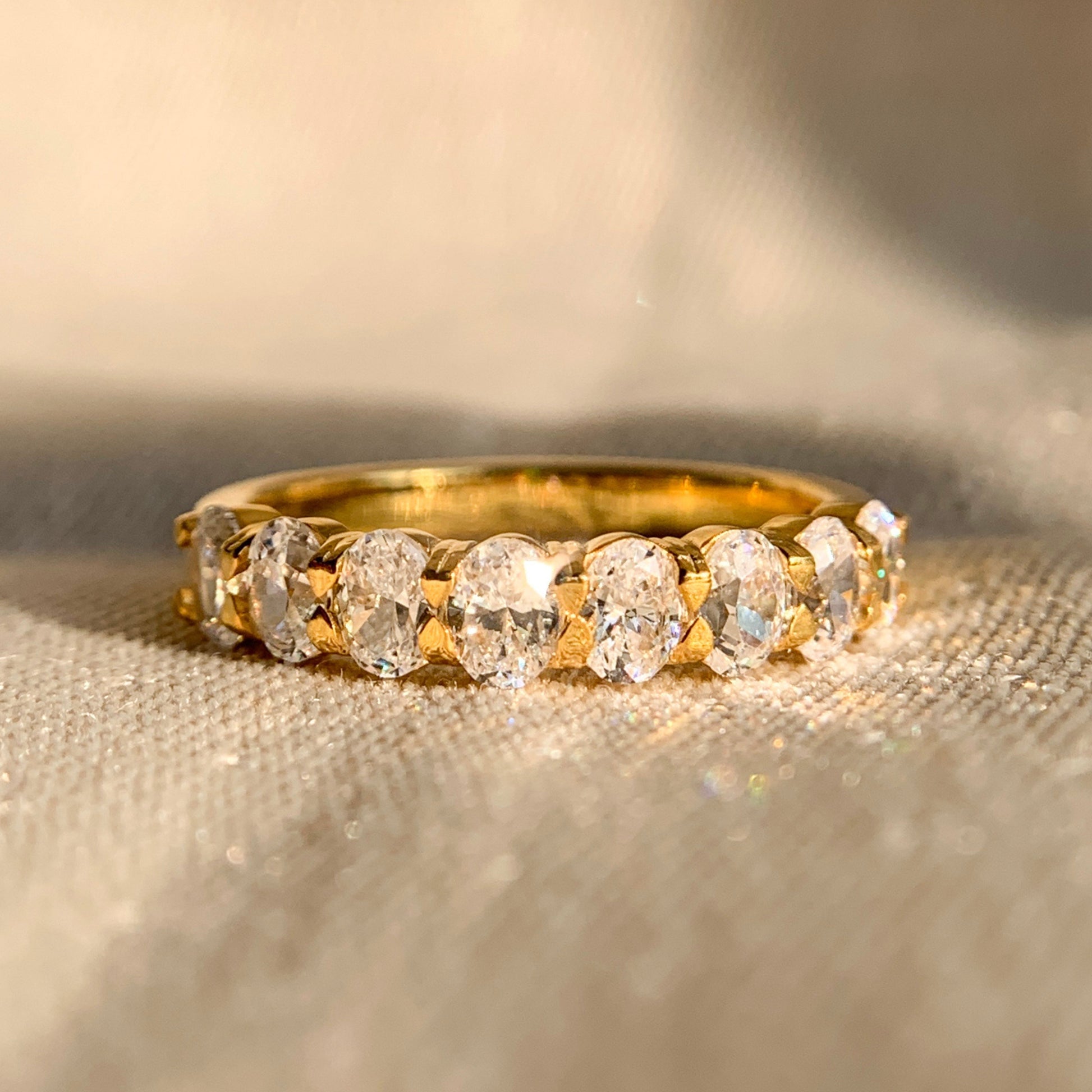 Oval cut half eternity wedding band in 14k yellow gold