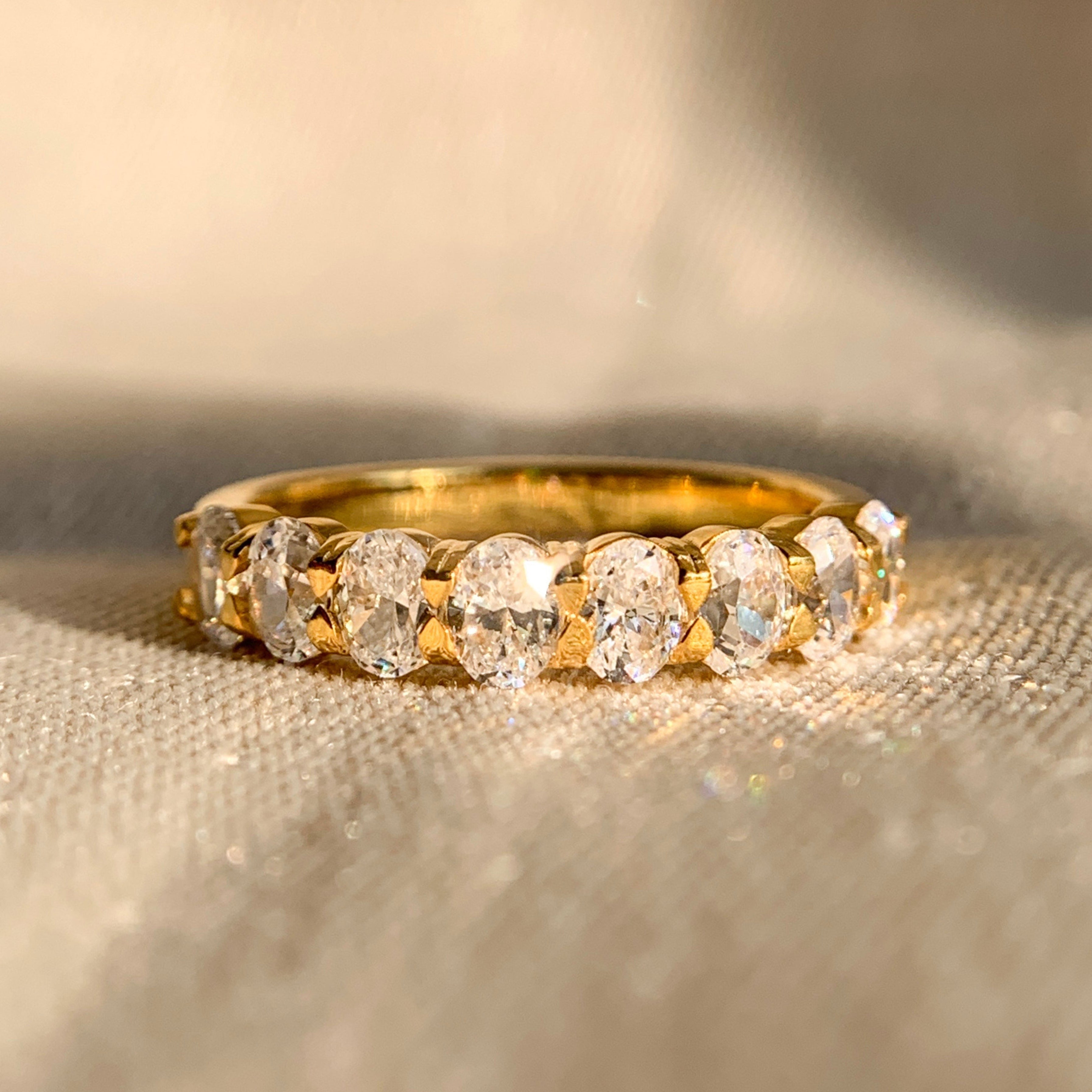 Oval cut half eternity wedding band in 14k yellow gold
