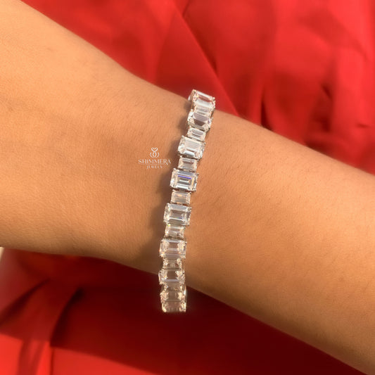 Silver bracelet with rectangular crystals on a wrist against a red background