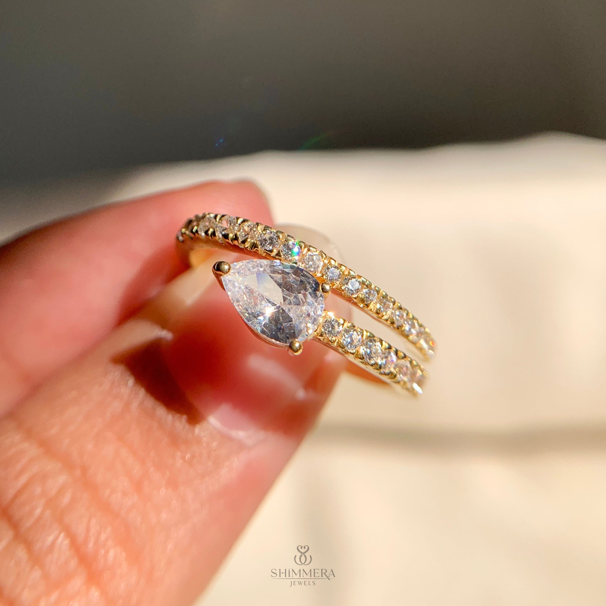 Pear cut diamond spiral band ring in yellow gold, sleek bypass style