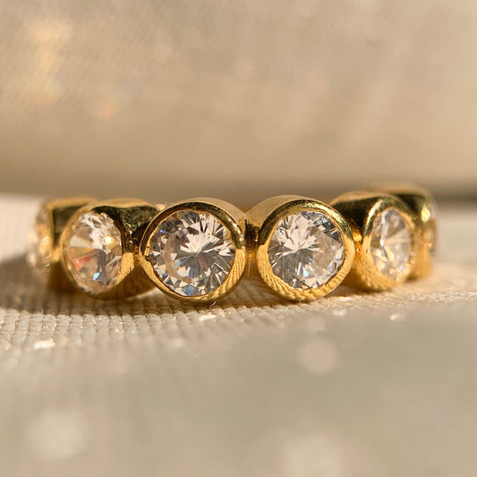 Round bezel set diamond eternity band in white gold