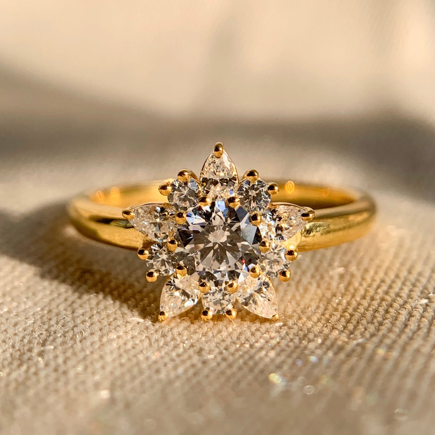Round and pear diamond cluster engagement ring in white gold