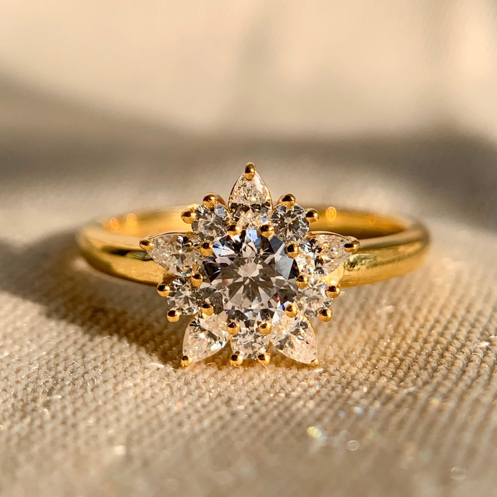Round and pear diamond cluster engagement ring in white gold