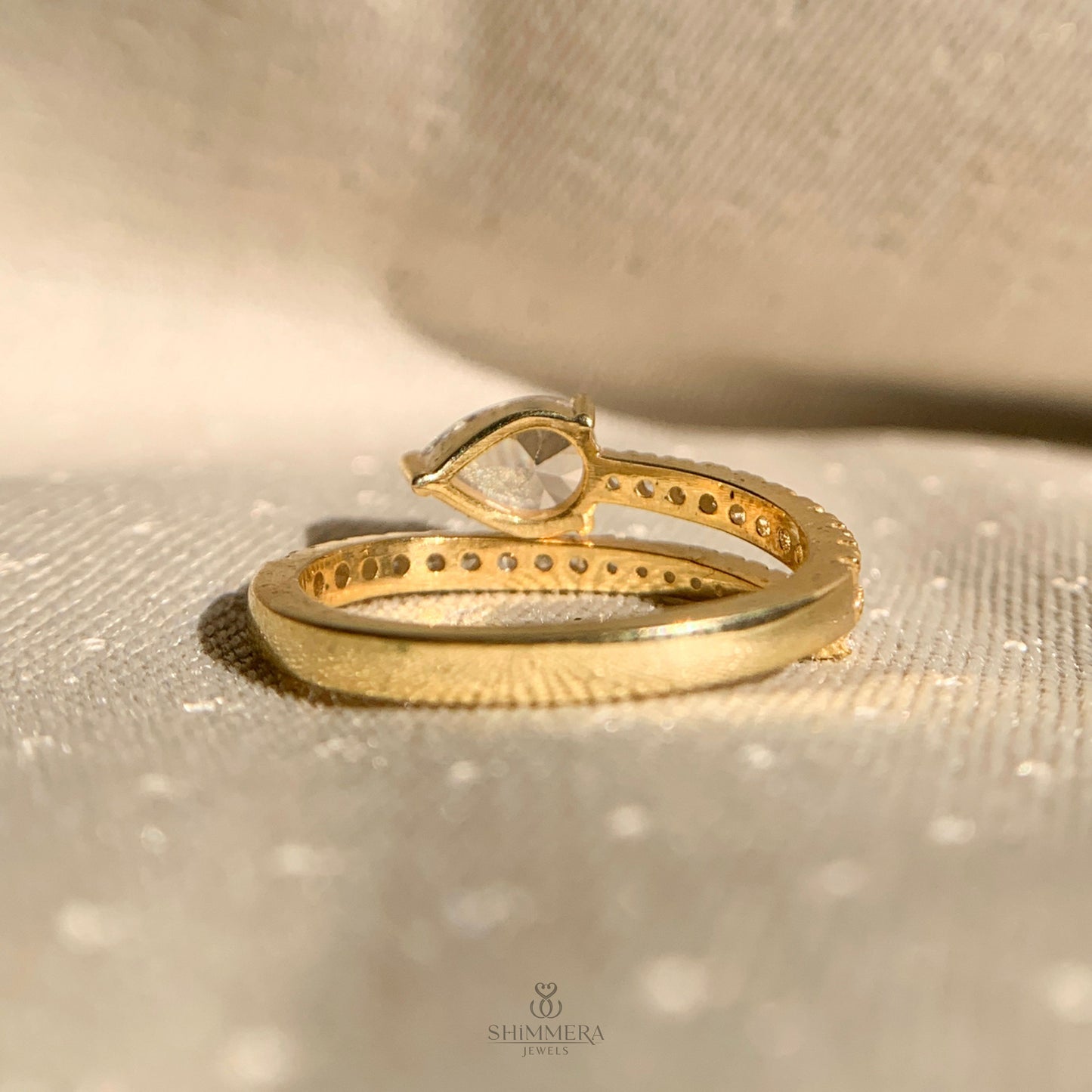 Dainty bypass ring with east west pear shaped diamond and pavé accents