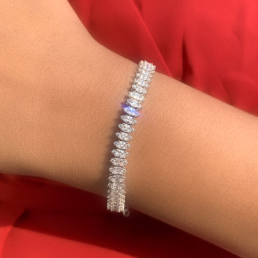Silver bracelet on a wrist with a red fabric background